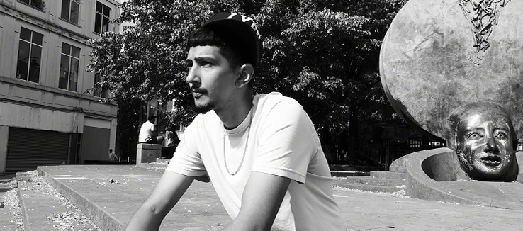Nayra J seated beside public art in Walsall